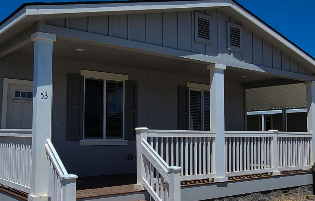 manufactured home with front porch, two front windows and door